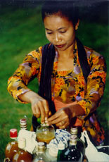 Indonesian woman preparing traditional medicine drink - jamu